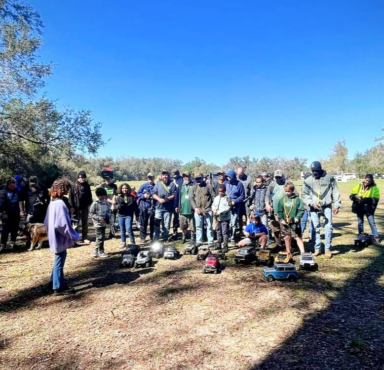 Inductees and their families lined up with their RC rigs in a park